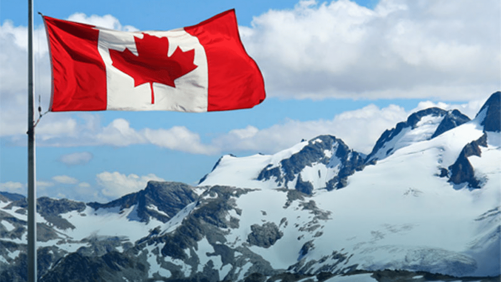 An image of a Canadian Flag in front of Mountains.