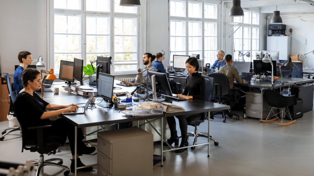 An image of an office with a bunch of staff working on their computers.