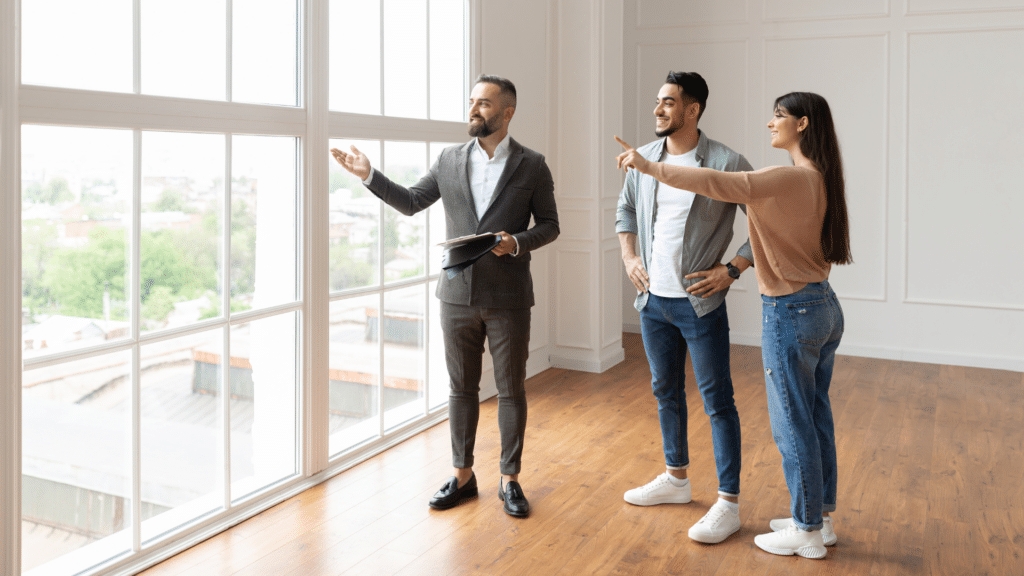 An image of a real estate agent in London Ontario showing a young couple a new property.